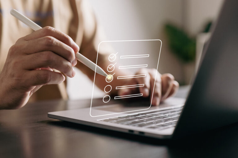 A person in front of a laptop checking a virtual checklist.